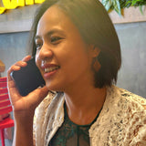Woman smiling while on the phone in a restaurant.