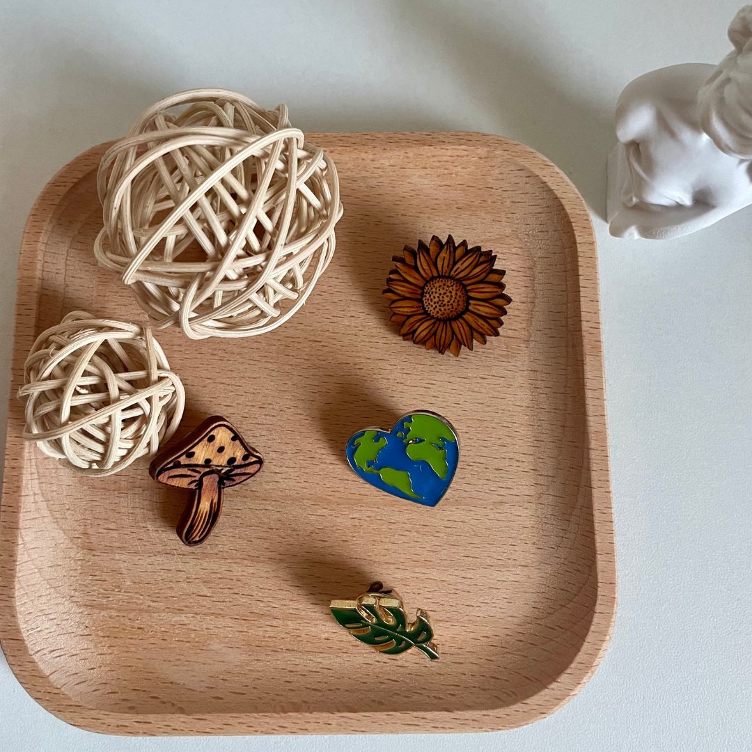 Collection of pins with a natural aesthetic on a wooden tray with twine.