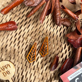 Wooden dangle earrings with a art deco geometric design on a natural background.