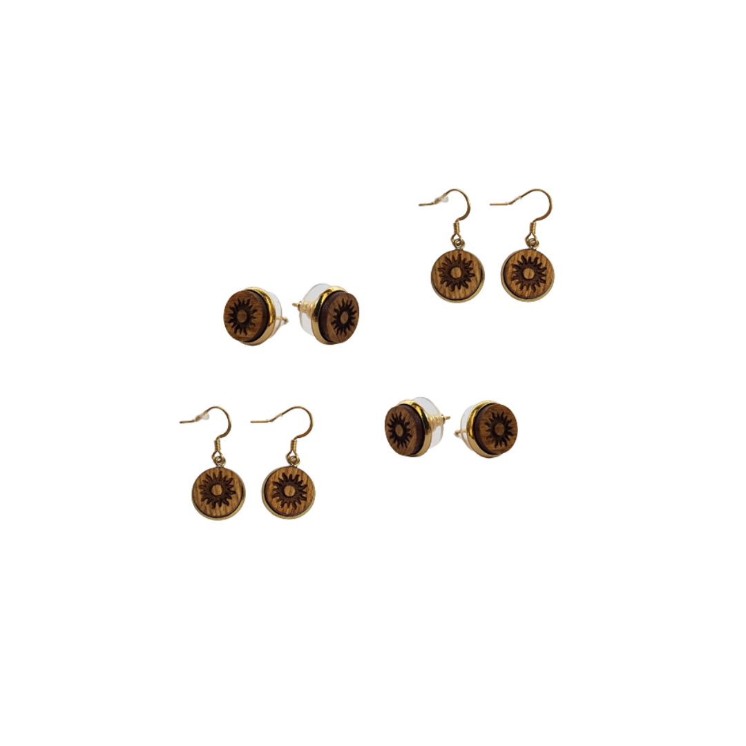 Wooden earrings with a sun design as both studs and dangles in a white space.