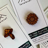 Two pins on cards with 'lovelevel' branding, featuring a sunflower and mushroom design.