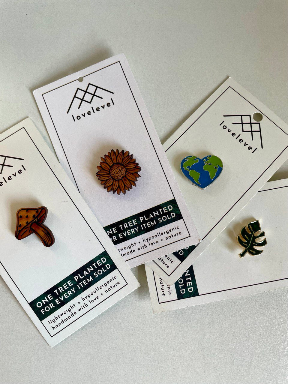 Collection of pins with a natural aesthetic on cards with 'lovelevel' branding.