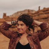 Woman in the desert wearing large wooden sunflower earrings
