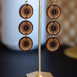 Wooden earrings on a stand with a decorative background