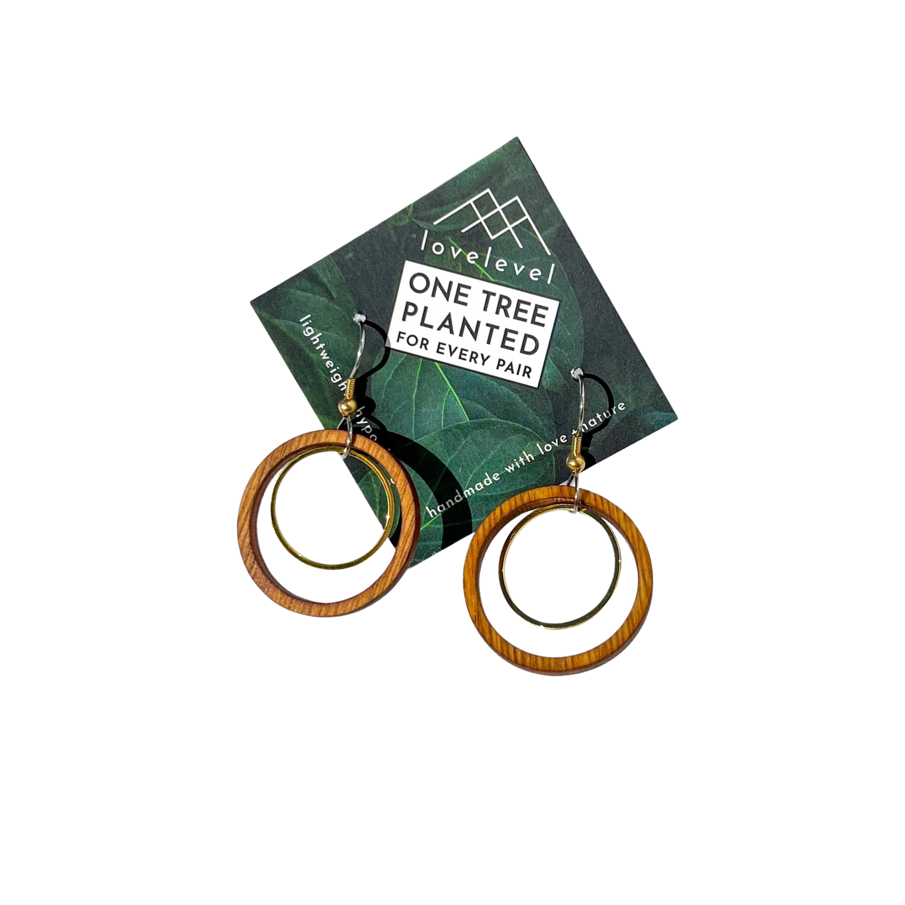 A pair of large circular earrings with a wooden circle surrounding a metal ring on a card with 'lovelevel' branding