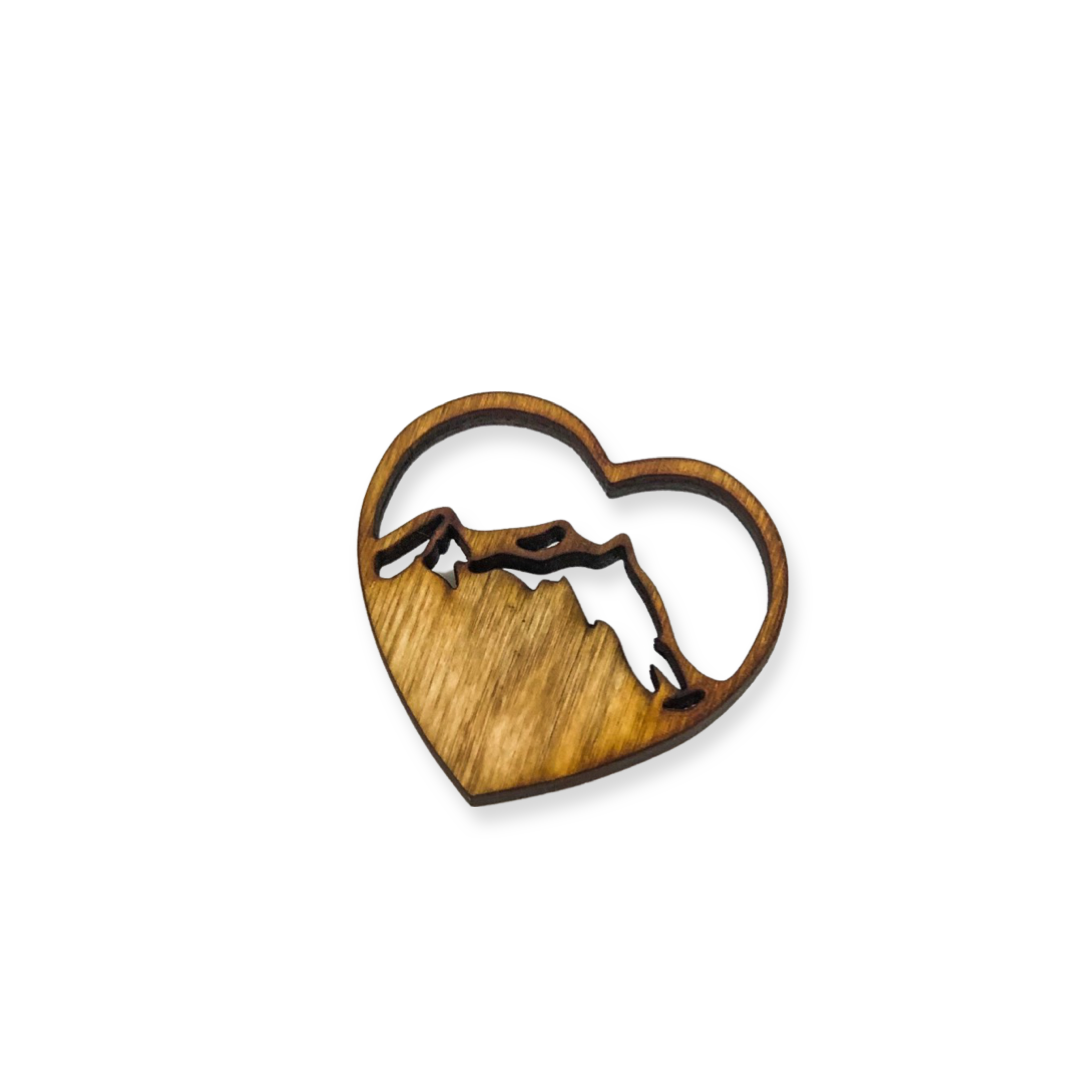 Wooden magnet in the shape of a heart with a mountain peak carved into the center