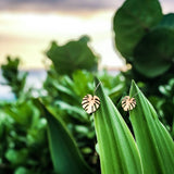 Pair of leave earrings on the tips of leaves with a natural background.