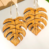 Wooden leaf-shaped earrings on a white background