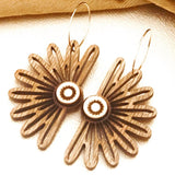 Wooden floral earrings on a beige fabric background