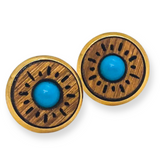 Pair of earrings with wooden circular design and turquoise centers on a white background