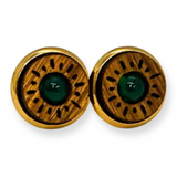 Pair of earrings with wooden circular design and green center on a white background