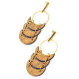 Pair of wooden earrings with gold accents on a white background