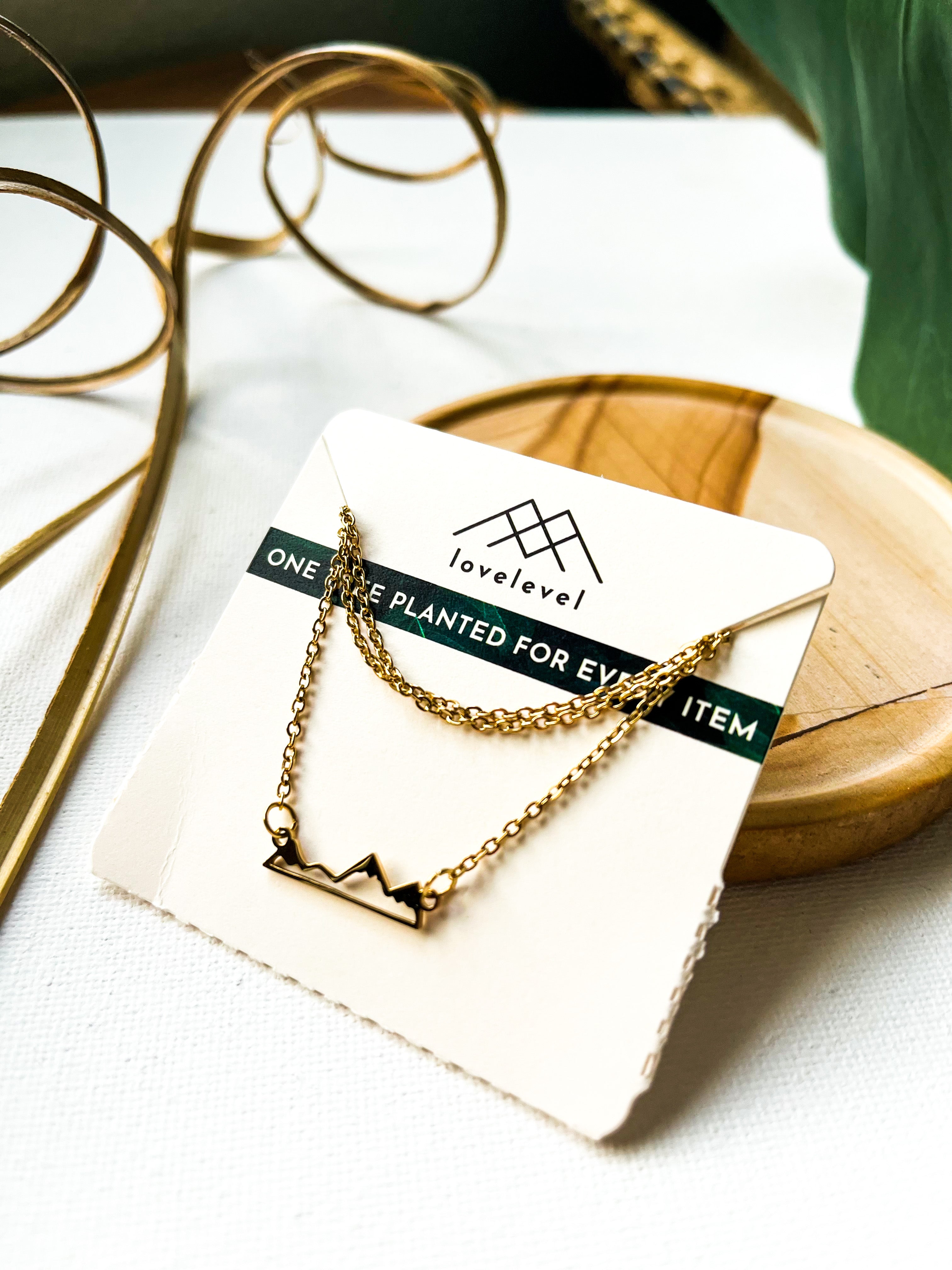 Mountain silhouette necklace on a card with 'lovelevel' branding.