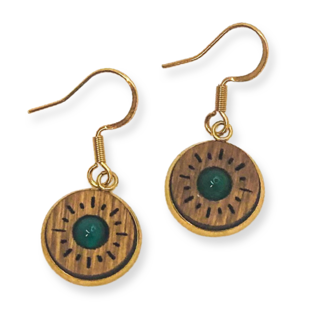 Pair of gold earrings with wooden disc and green center on a white background