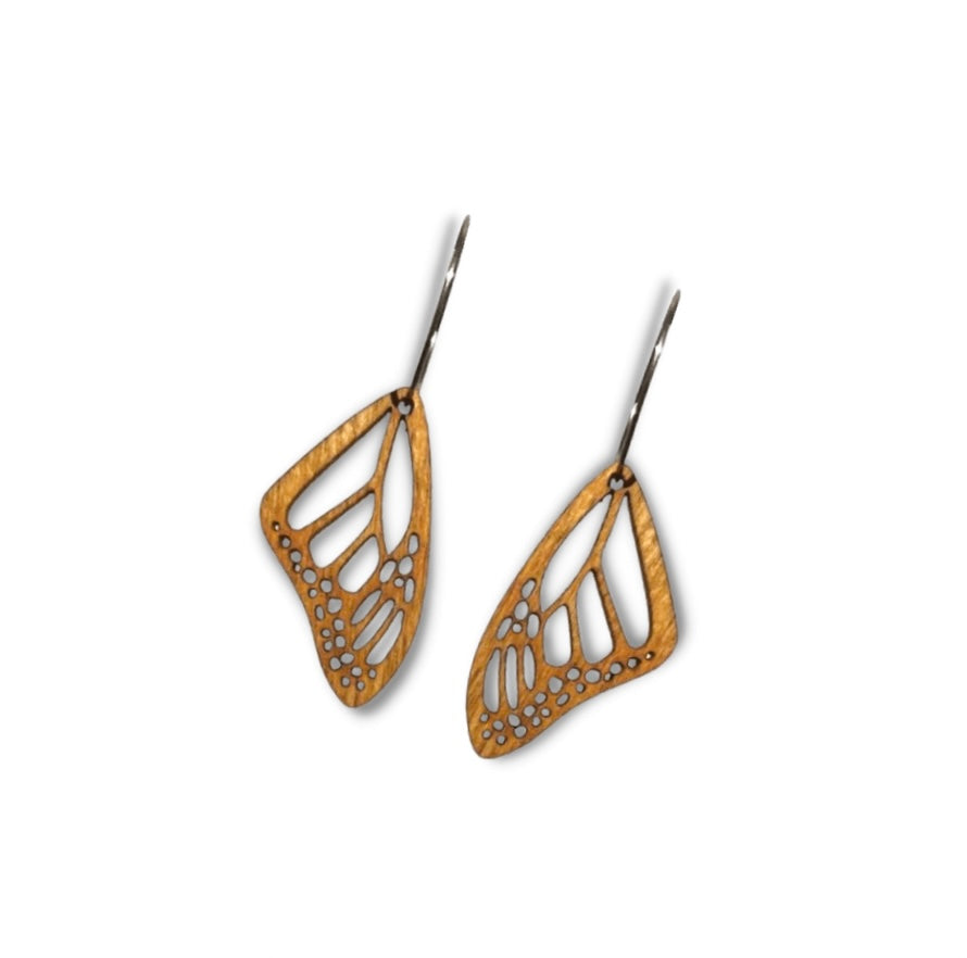 A pair of wooden earrings cut in the shape of butterfly wings on a white background.