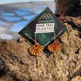 Wooden art deco shell earrings with a gold bar hanging down from the shell on a card with "lovelevel" branding on a rock.