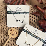 Mountain peak necklaces on cards with 'lovelevel' branding against a natural background.