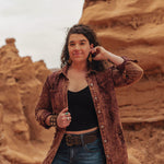 Woman standing in a desert landscape with rock formations.