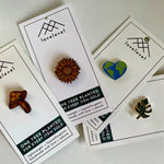 Collection of pins with a natural aesthetic on cards with 'lovelevel' branding.