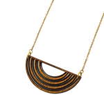 Gold necklace with a half-circle wooden pendant on a white background