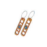Wooden earrings with moon patterns cut out surrounding a moonstone gem.