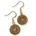 Pair of gold earrings holding a wooden disc with circular designs on a white background